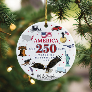 A round ceramic ornament, honoring 250 years of freedom. Featuring a collage of iconic images-from the Liberty Bell, 13 colonies, feather quill, and horse-drawn carriage to modern symbols like the Statue of Liberty, fighter jets, and cell phones and ipads.