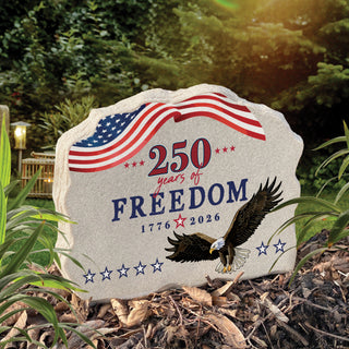 Standing garden stone with patriotic bald eagle, flowing American flag, honoring 250 years of freedom.